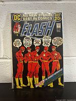 Front cover of The Flash #217 comic book, showing the comic in a clear protective sleeve leaning against a white brick wall.