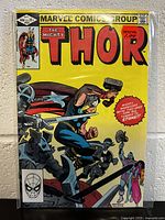Photo of The Mighty Thor #323 comic book cover showing Thor fighting armored figures, bright yellow background, near mint condition.