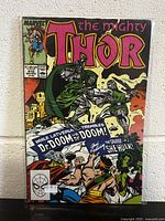 Photo of The Mighty Thor #410 comic book cover showing Dr. Doom and She-Hulk characters, issue price and number visible.