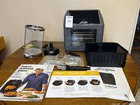 All items on table: oven, baskets, racks, spit, manuals