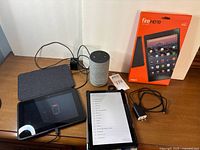 Table with both tablets powered on, Echo speaker, Fire HD 10 box, chargers