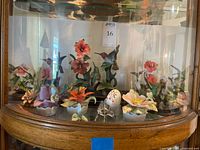 Full view of cabinet shelf showing all hummingbird figurines and trinket boxes