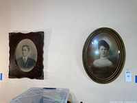 Both framed portraits on wall for scale and context