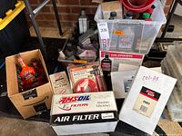 Group shot of lot showing boxed air filter, pump kits, clear tote with oils