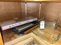 Overall lot view showing metal pans, silicone liner, PanSaver box, glass dishes