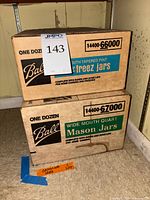 Stacked cardboard cases of Ball jars, showing labels for pint and quart sizes