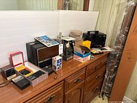 Overall view of projectors, radios, reel cases and accessories on dresser