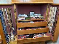 Overall view of jewelry cabinet with necklaces, watches, beads
