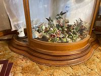 Wide view inside cabinet showing large bouquet figurine and surrounding pieces