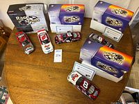 Overview of four boxed #8 Budweiser die-cast cars on table