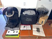 Keurig brewer, carry bag with contents, XQ-606 wrapped, manuals, tray visible