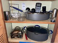 Overall view of cabinet shelf showing most cookware and tools