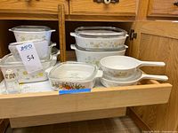 Drawer with multiple CorningWare casseroles, skillets, tile trivet