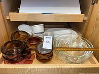 Drawer view showing amber Corning Visions bowls with lids, white mini soufflé dishes, oval casseroles and clear glass bowls