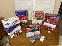 All five die-cast cars with corresponding boxes arranged on table
