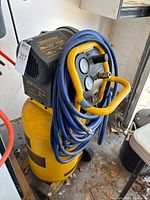 Full view of DeWalt D55168 compressor with hoses coiled around handle
