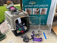 Overall lot showing carrier, gate box, leashes, bowls, balls