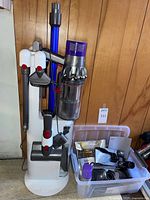 Vacuum on freestanding stand with several attachments and tub of accessories