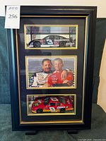 Front view of black framed mirrored shadow box with two model cars and driver photo