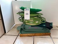 Stacked collapsible bowls, sheet pans, potholders and pot savers with ruler for scale