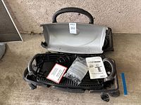 Open grill with manual and accessories displayed