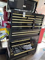 Full view of Homak black tool chest on casters with drawers open showing tools