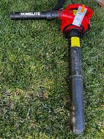 Full view of Homelite red handheld leaf blower on grass