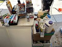 Wide view of table and box holding assorted tubes, aerosols and bottles