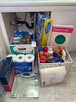 Overall view under sink with tissue, scale, boxes of supplies