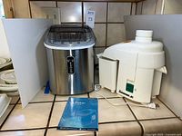 Ice maker, juicer and manual on countertop