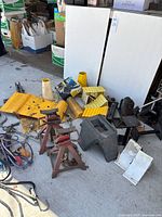 Overall lot showing jack stands, wheel chocks, bottle jacks, hitch mount, flex pads box, bungee cords