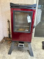 Front view of red Masterbuilt electric smoker on stand