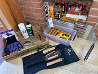 Group shot of lot showing spatula, barbecue tool set, glass lids, firestarter packs in bin, lighters