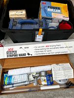 Overview of lot showing power roller box, striping wand box, open kit with accessories and black storage tote