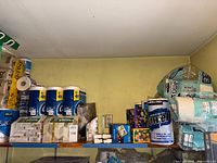 Top shelf with toilet paper packs, loose roll, paper towels