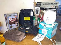 Table with HoMedics BackEnergizer cushion, Shiatsu Pillow, Vicks humidifier, respective boxes visible