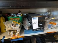Shelf with multiple bins of plumbing parts including brass fittings, PTFE tape, valves