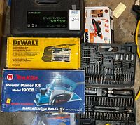 Stacked tool boxes showing Dualsaw CS450 case, DeWalt DW443 sander box, Makita 1900B planer box and bit set case