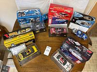 Overhead view of all five die-cast cars with their display cases and boxes on table