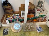Wide view of lot showing woven tote, boxes of kits, green fabric needle case, Ziploc box, sewing machine boxes out of sight, plastic organizers on floor