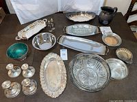 Overall view showing all candlesticks, trays, bowls, pitcher and glass pieces