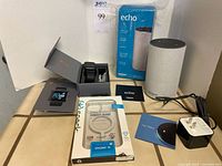 Group shot showing Yamay smartwatch, two Amazon Echo devices (one sealed, one used), Speck iPhone 13 case and accessories