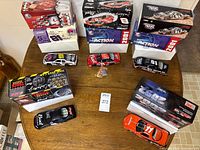 Overhead view of five boxed 1:24 scale NASCAR die-cast cars and confetti packet
