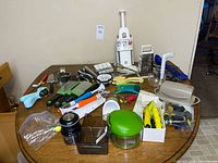 Overview of entire lot on table showing graters, mandoline, chopper, slicers and utensils