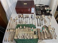 Entire flatware set laid out with chest and grouped utensils
