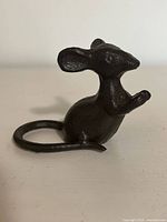 Front-side view of the black cast iron mouse figurine showing raised front paws and curled tail.