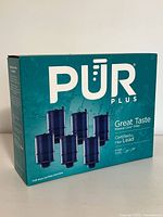 Front and sides of PUR Plus faucet water filter packaging box showing brand, product name, and depiction of five filter cartridges.
