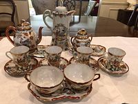 Full view of 14-piece Kutani tea/coffee set arranged on table