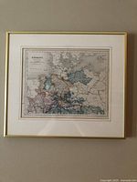Full view of framed hand-colored map with mat and gold frame