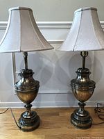 Front view of both brass urn table lamps with shades